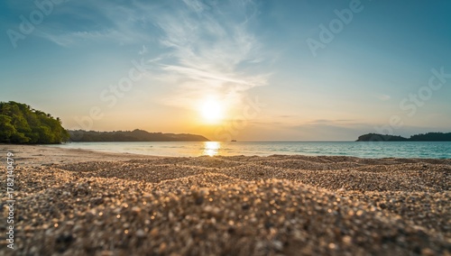 Fototapeta Naklejka Na Ścianę i Meble -  A close-up of sand on a beach under a clear summer sky, highlighting the isolation of serene coastal landscapes