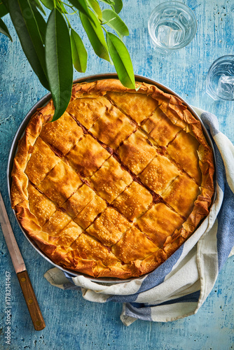 baking tray with meat pie on a blue background