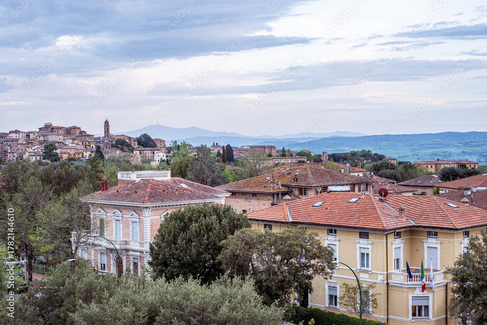 Obraz premium Ancient stone buildings nestled among lush greenery create a captivating landscape view, inviting exploration and travel to this historic city with rich cultural heritage