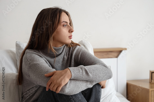 Sad young woman sitting in ...