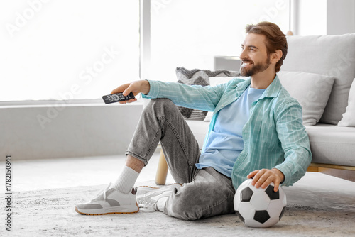 Young man with TV remote co...