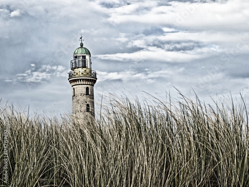 Blick durch die Dünen auf den alten Leuchtturm des Ostseebades Warnemünde in Rostock, Deutschland, entsättigte Farben