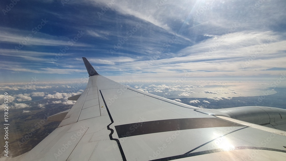 Obraz premium View from Airplane Window with Wing and Blue Sky