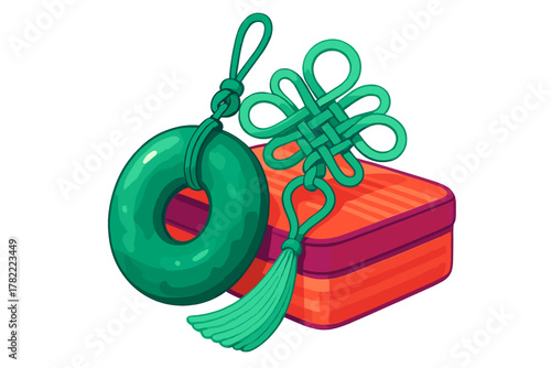 Traditional Chinese knot charm with jade ring and tassel resting on a decorative orange box