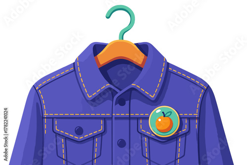 Purple denim jacket hanging on a wooden clothes hanger with an orange fruit pin badge