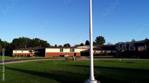 American Flag Waving Proudly on a Tall Pole Under a Clear Blue Sky.
