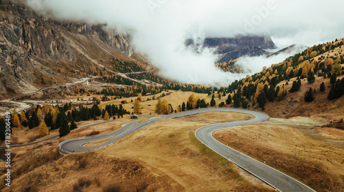 Twisted snake-like asphalt road. Pass near Cortina mountain. Aerial majestic view of popular place at autumn season, background
