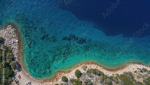 Fototapeta Naklejka Na Ścianę i Meble -  Stunning bird's-eye view of a turquoise lagoon near a large island, popular among locals and tourists for swimming.