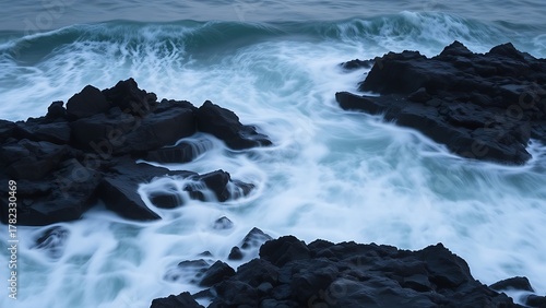 weakness. Ocean waves washing over dark rocks in a long exposure seascape. travel magazines, destination branding, designed for outdoor magazines and nature guides, used by data analysts.