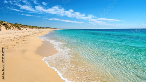 Fototapeta Naklejka Na Ścianę i Meble -  A beautiful coastal landscape with a golden sandy beach, turquoise waters, and clear blue skies.