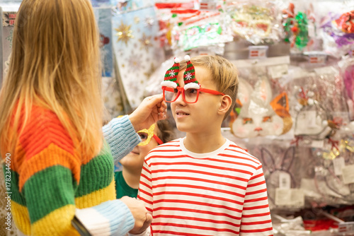 Family mom, son and daughter shopping Christmas presents and decoration in shopping mall	