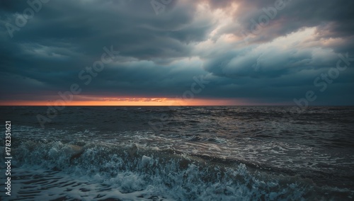 Fototapeta Naklejka Na Ścianę i Meble -  Stormy skies over a turbulent sea with crashing waves at dusk