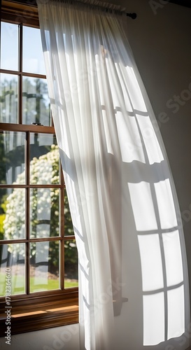 Sunlit Window with Sheer Curtain Blowing in the Breeze.