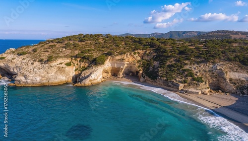 Fototapeta Naklejka Na Ścianę i Meble -  Aerial view of rocky beach with turquoise waves, showcasing natural beauty and seasonal change