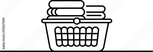 Laundry basket filled with folded clothes ready for ironing or putting away in a minimalist style