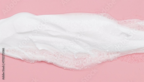Skincare cleanser foam texture, various cleansing products in soft foam against a pink backdrop, beneficial for daily hygiene