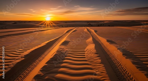Golden Hour Beach Scene - Tire Tracks in Sand, Sunset Glow.