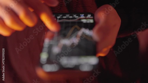 スマートフォンで為替チャートを確認する手元クローズアップのスローモーション動画