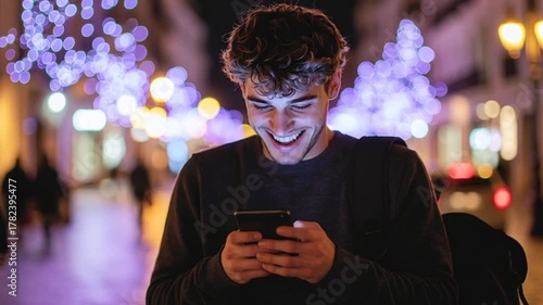 Smiling young man uses smartphone at night city, illuminated street with bokeh lights, technology