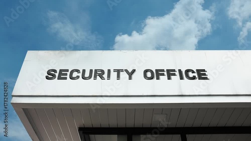 Security Office word sign displayed on a commercial or governmental building under a clear blue sky, symbolizing private protection, surveillance, safety management, control room, monitoring