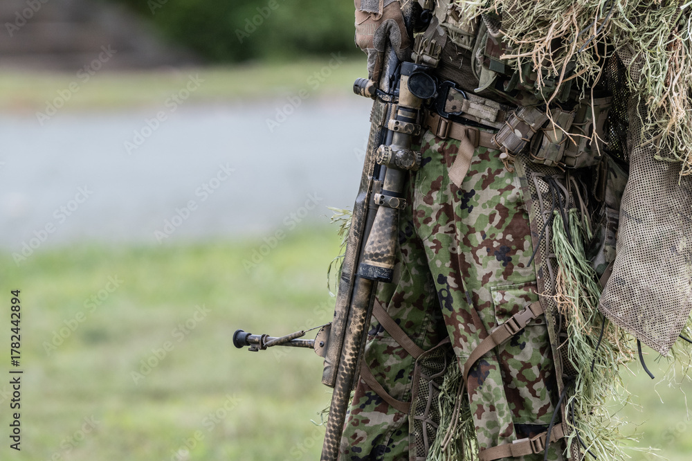 Obraz premium ギリースーツを着て狙撃銃を構える軍人