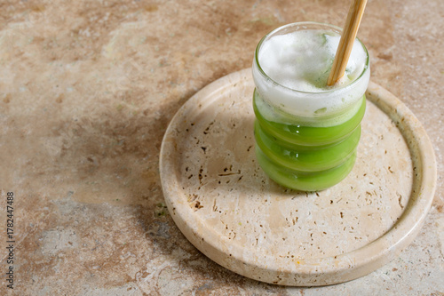 Matcha latte glass, matcha bowl, a bamboo whisk Chasen on travertine tray