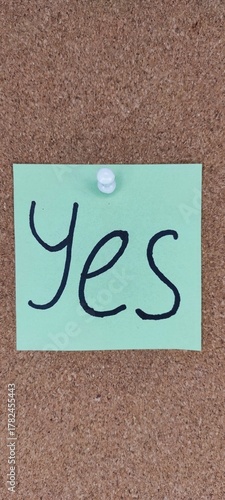 Note on Cork Board Shows Positive Affirmation With the Word Yes Written in Large Letters on a Green Sticky Note