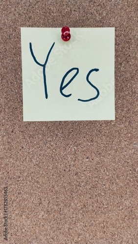 Sticky note YES on cork board – business decision or agreement concept