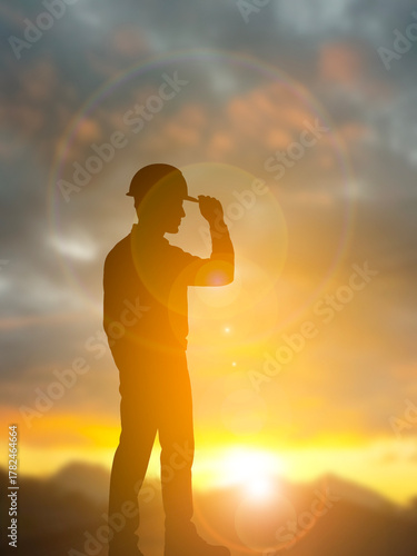 Engineer Silhouette Touching Helmet at Sunrise