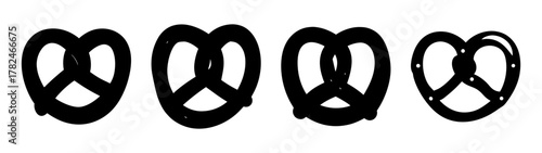 Four black pretzels of varying sizes arranged horizontally on a