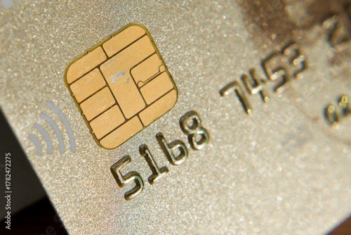 Close-up picture of a golden credit card. A microchip and numbers on a bank card.