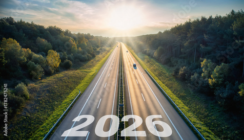 Wallpaper Mural Wide shot highway through nature with sunbeam at horizon, photorealistic scene, tranquil atmosphere, green forest, clear sky, and year 2026 marked on road Torontodigital.ca