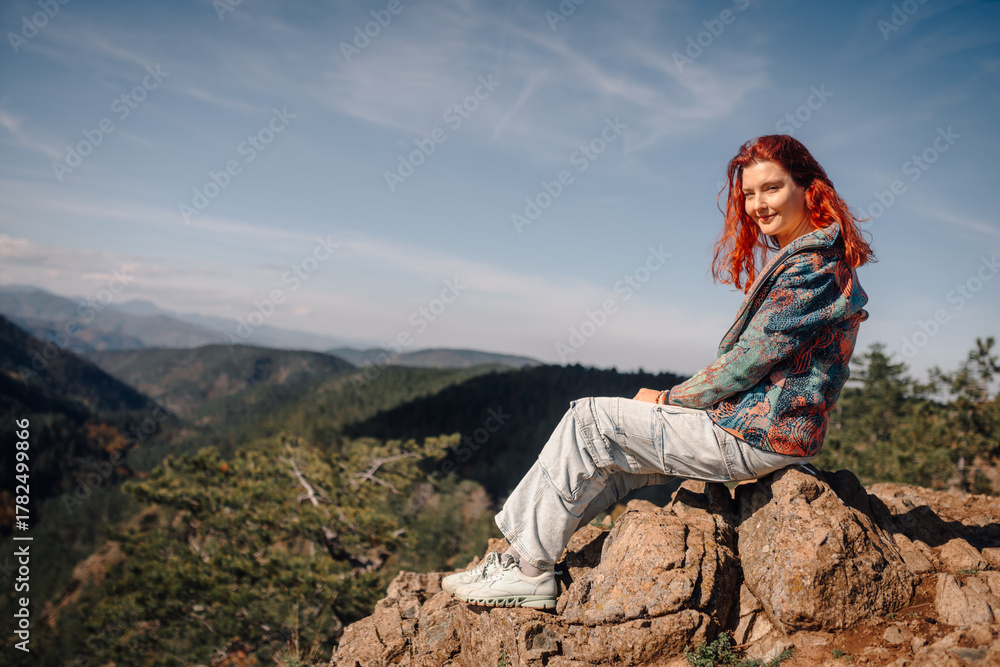 Naklejka premium Woman with red hair enjoying mountain view while hiking