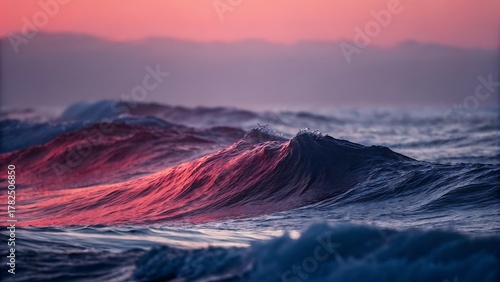 Fototapeta Naklejka Na Ścianę i Meble -  Vibrant crimson light illuminates ocean wave at sunrise or sunset