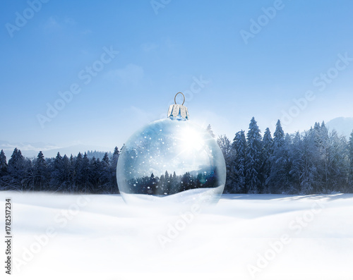 Gläserne WEihnachtskugel mit Wintermotiv in einer Bewaldeten Schneelandschaft