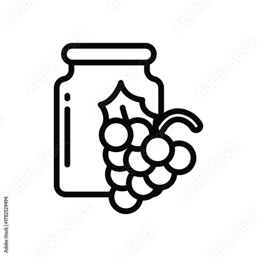 A jar with a bunch of grapes next to it