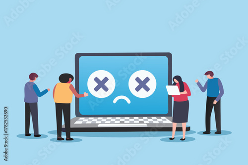 People looking at a broken laptop with a sad face and crossed out eyes on the screen