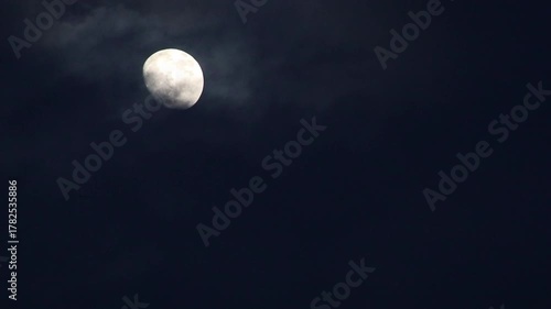 Half a moon emerges from the clouds. During the rainy season, dark clouds rise above the earth at night, blocking out the moonlight for some time.