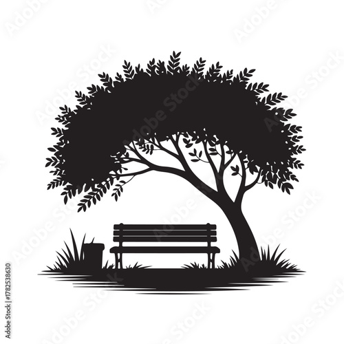 Silhouette of a park bench under a large tree with grass and a trash can