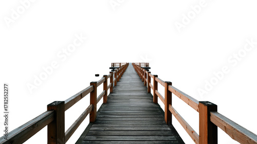 Wooden pier with handrails extending towards the horizon, framed by the bright sky, evoking a sense of tranquility and an invitation to embark on a journey.