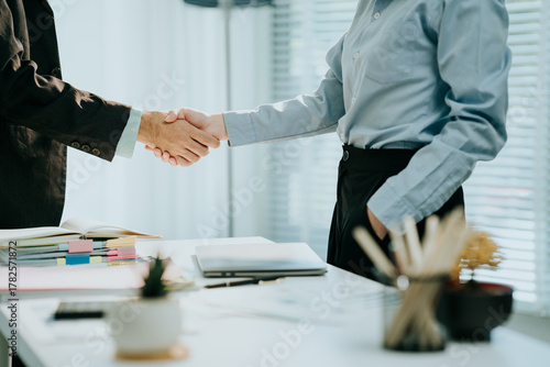 Wallpaper Mural Partnership Agreement: A business professional shaking hands in a bright, modern office setting, symbolizing deal completion and collaboration. Illustrating professionalism. Torontodigital.ca