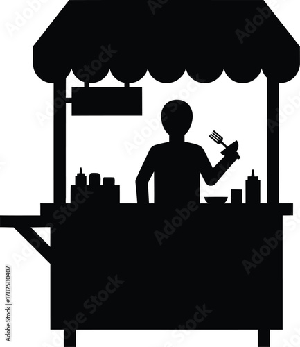 Silhouette of a food vendor at a street stall