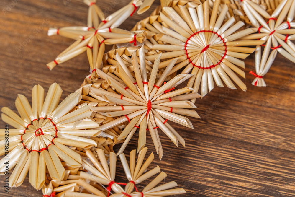 Fototapeta premium Straw star on wooden background. Christmas tree decoration made of straw.