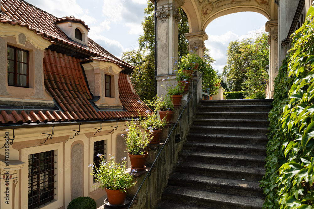 Fototapeta premium Prague, Czech Republic – August 6, 2025: Kolowrat Garden, Baroque garden terraces and stairway beside historic villas in Prague, Czech Republic on a sunny summer day