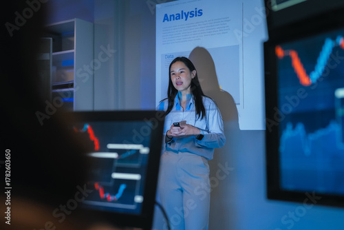 young Asian software development manager leads a late-night office discussion with his executive team, mentoring developers and analyzing source code to guide programming and project development	