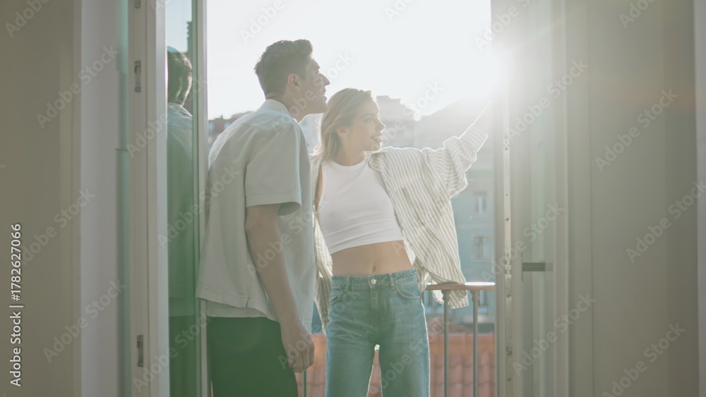 Obraz premium Romantic people enjoying cityscape on balcony. Smiling sweethearts talk on date