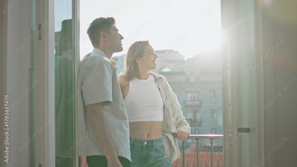 Obraz premium Relaxed lovers standing balcony enjoying cityscape on date. Casual couple talk