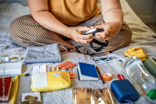 Equipment check - woman testing headlamp while assembling emergency go-bag