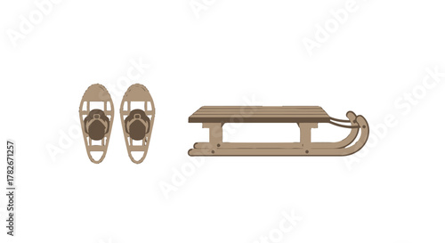 Vintagestyle wooden sled with slatted seat and a pair of traditional snowshoes winter sports equipment.