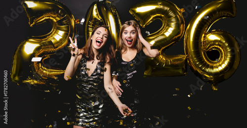 Beautiful Women Celebrating New Year. Happy Girls In Stylish Dresses Holding Gold Balloons, Having Fun At New Year's Eve Party
